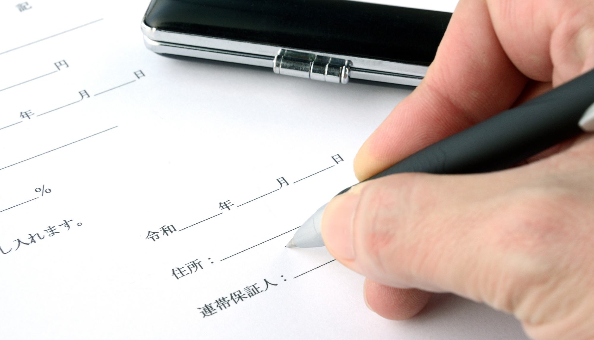 連帯保証人の欄がある契約書に記入する手元